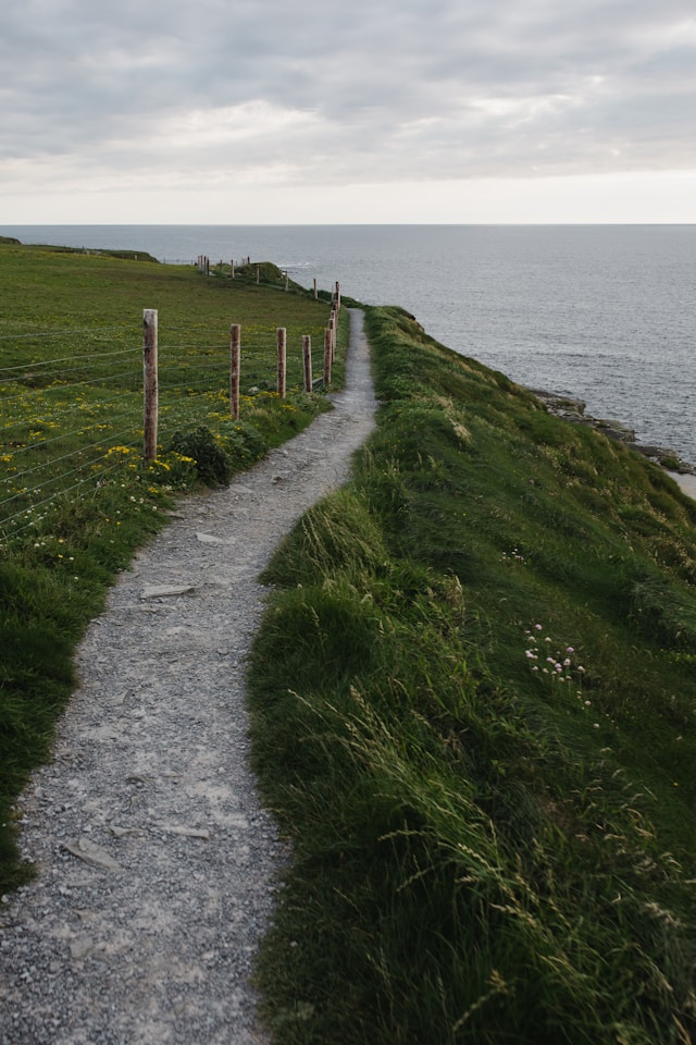 A path along a steep hill top by the sea.