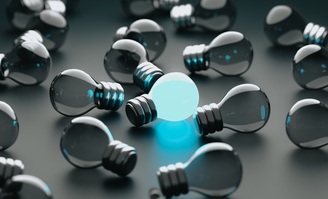 a-c-nulv4JkAJtk-unsplash One lit lightbulb in a group of unlit bulbs.